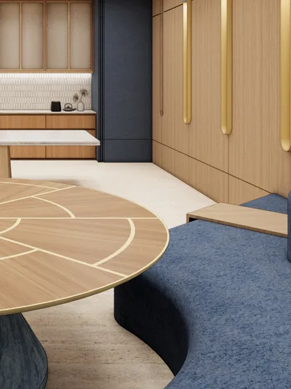 A render of a collaborative lounge area, featuring a custom curved sofa in a rich blue fabric and a bespoke coffee table with brass inlay. This zone is designed to encourage spontaneous conversations and team interaction in a comfortable, relaxed setting.