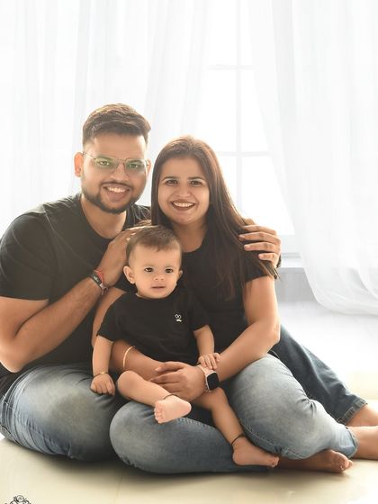 A classic family-of-three portrait against a bright, clean background. The simple, happy pose makes for a perfect, timeless photo to hang on the wall.