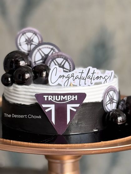 A sleek and modern cake to celebrate buying a new Triumph motorcycle. I used the brand's logo and wheel toppers to create this celebratory design.