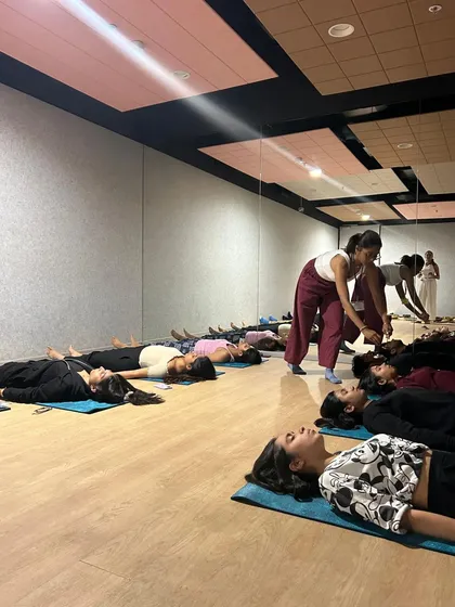 Guiding students into Savasana (Corpse Pose) at the end of a corporate wellness session. This final resting pose is crucial for integrating the benefits of the practice and achieving deep relaxation.
