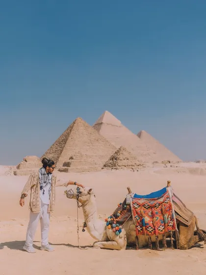 Interacting with a camel in front of the Giza pyramids. This photo adds a touch of local culture and connection to the travel story, making the experience feel more authentic.