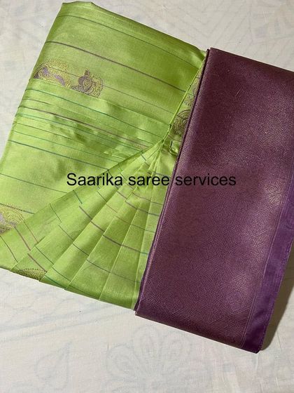 A light green saree with a purple border, showing the perfect pleats that make draping effortless.