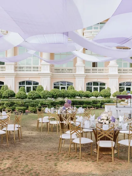 A wide shot of the outdoor dining area, with flowing lavender and white drapes creating a beautiful canopy overhead.