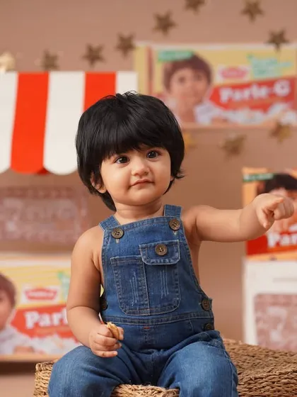 An identical shot showing the baby girl pointing, offering a slight variation in pose for the Parle-G themed gallery.