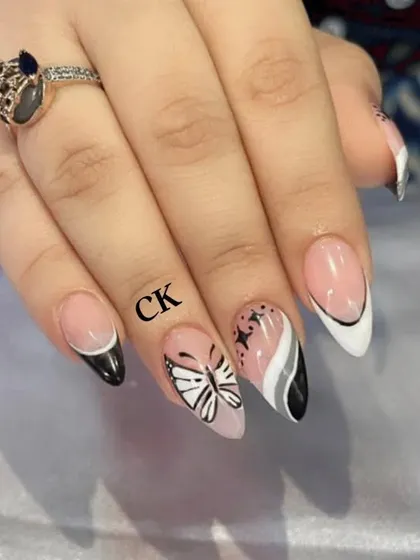 A close-up of the intricate butterfly and French tip design.