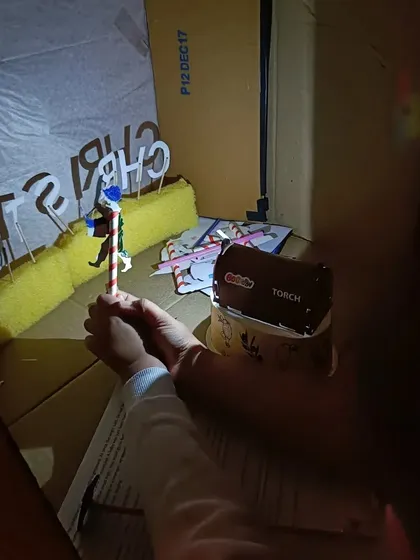 A behind-the-scenes look at how the shadow puppets are operated with a simple torch.