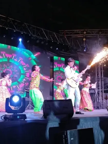 We know how to bring the party. This shot captures the energy of a New Year's Eve bash we produced, complete with live music, dancers, and special effects like this sparkler guitar act. We handle everything to make your celebration a hit.