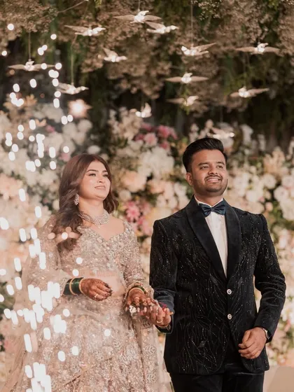 The grand entrance as a married couple. The bride's sparkling lehenga and shimmering makeup create a magical effect with the sparklers.