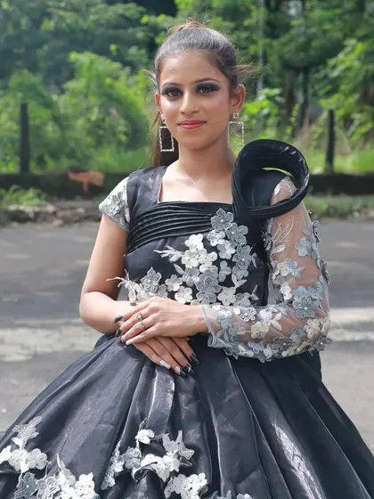 A chic and modern look in a black gown. The student has created a sharp, defined eye and a polished hairstyle.
