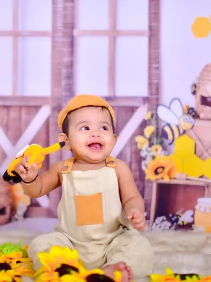 A happy baby in a honeybee-themed setup.
