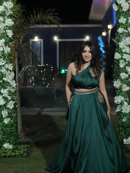 A poised, full-length shot of the green gown. This provides a clear and elegant view of the entire outfit for potential buyers.