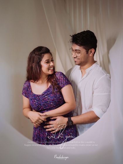 A sweet and happy moment between a couple, framed by white curtains.