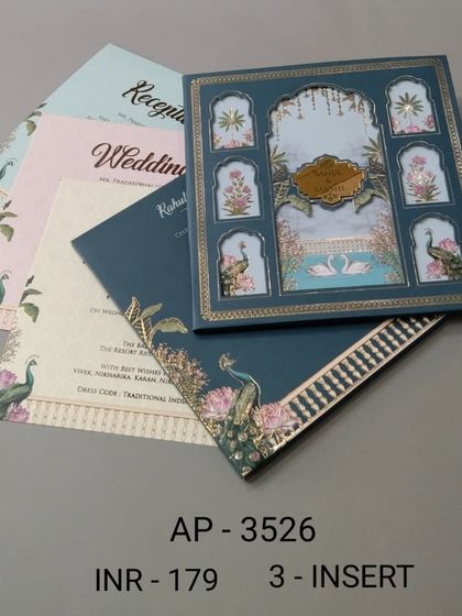 This boxed invitation in a deep teal color features multiple windows showing peacocks and floral motifs. The set includes three colorful inserts for your various wedding events.