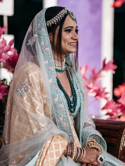 The bride looking elegant at her pre-wedding function. The decor features bright pink florals that complement her beautiful attire.