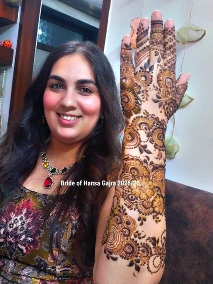 A portrait of a bride with her intricate floral mehendi. Her joyful expression and the detailed art on her arm create a stunning and memorable image.