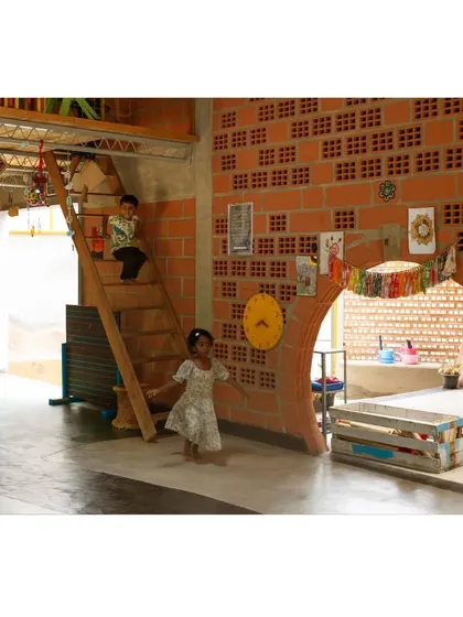 Every corner is an invitation to explore. Here, a small wooden staircase and a child-sized archway built from hollow clay blocks create a playful environment that encourages physical activity and imaginative journeys within the school.