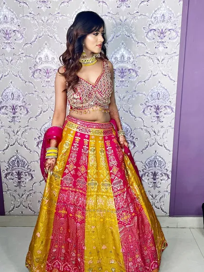 The full lehenga in vibrant pink and yellow. The makeup is kept soft and neutral to let the outfit be the star.