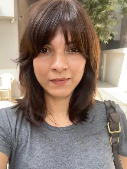 A shoulder-length haircut with soft, face-framing bangs. This style adds lots of texture and movement, making it a great wash-and-go option.