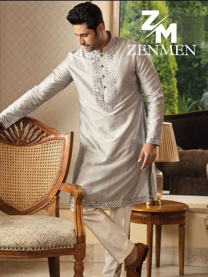 A model wearing a lustrous grey silk kurta with intricate mirror work along the placket and hem. A perfect blend of shimmer and sophistication.