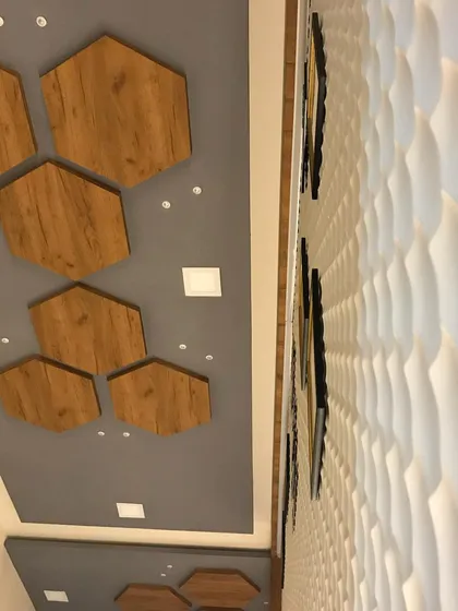 A ceiling detail from the clinic, where wooden hexagonal panels are set against a grey background. This design is mirrored in other elements throughout the space for a cohesive look.