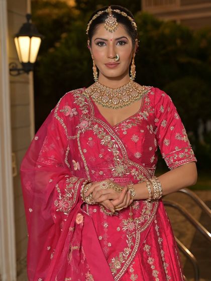 A complete bridal look featuring a heavy, gold-plated Kundan necklace, haath phool, and maang tikka, all available for rent.