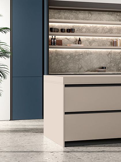 This design showcases how pocket doors can be used to conceal a functional kitchen workspace. The deep blue cabinets and integrated appliances create a sleek, monolithic look when closed.