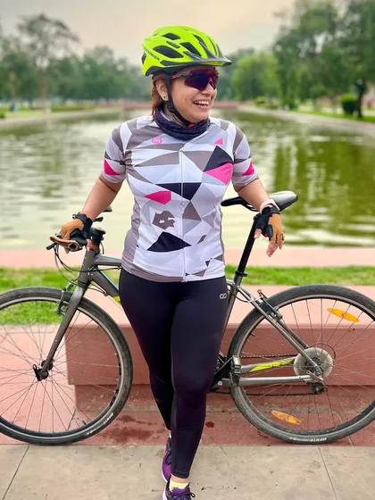 A female cyclist smiling by the water. Our club has a strong and growing community of women cyclists.