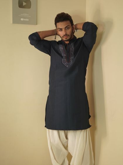 Influencer Shadab Khan in a dark navy kurta with a dhoti. The pose highlights the modern, confident attitude of the wearer.