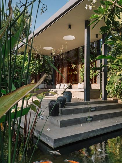 This gazebo, set beside a koi pond, is a perfect spot for quiet reflection. The design uses simple forms and natural materials, allowing the focus to remain on the calming presence of water and greenery.