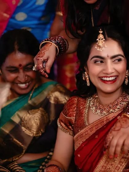 A beautiful, candid shot of a bride laughing with her family during her engagement ceremony. We capture the joy of your celebration.