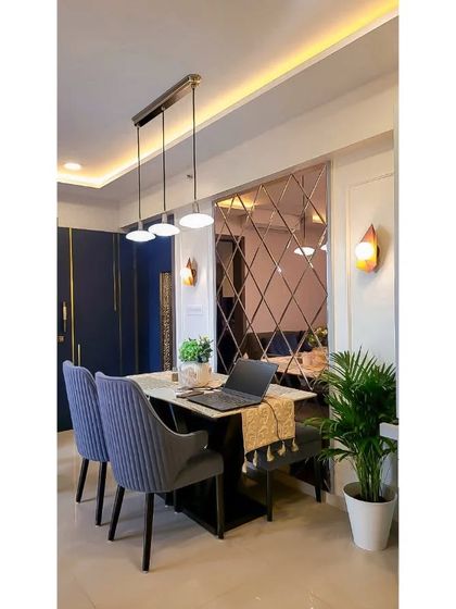 This pleasant and cozy dining area is one of my favorite projects. The combination of the mirrored wall, pendant lights, and comfortable seating creates a warm and inviting atmosphere.