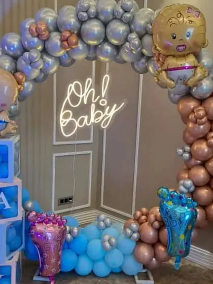 A duplicate image showing the popular 'Oh! Baby' shower decoration. The mix of metallic colors and the neon sign creates a very stylish and celebratory atmosphere for the parents-to-be.
