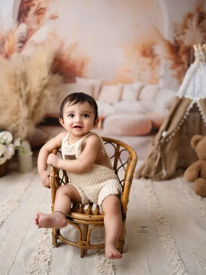This little one is posing with confidence in his miniature cane chair. The boho theme with pampas grass is a popular and timeless choice.