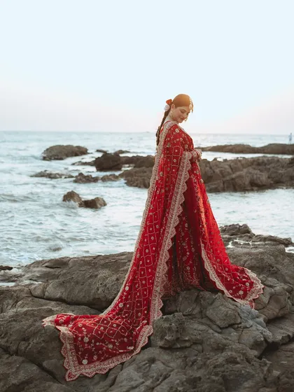 We believe every bride deserves a portrait that feels like a piece of art. Here, we used the dramatic backdrop of the sea and the flowing red lehenga to create a timeless, powerful image of Alifa on her big day.