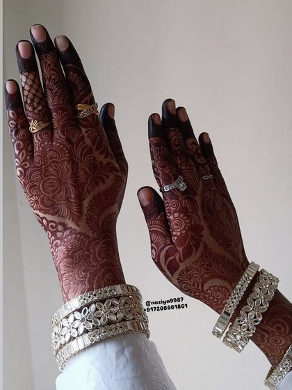 The dark, elegant stain looks so beautiful with the bride's silver bangles. This is the goal for every bridal mehendi.