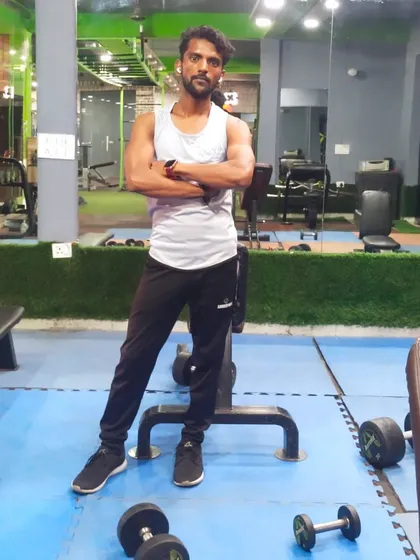A relaxed but confident stance in the gym, surrounded by the tools of the trade. This is my element.