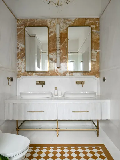We transform bathrooms into personal spas. This award-winning master en-suite features a dramatic dialogue between Mango Onyx and White Balmain Marble, with custom fluted vanities and checkerboard flooring to create a space that is meant to be felt, not just seen.