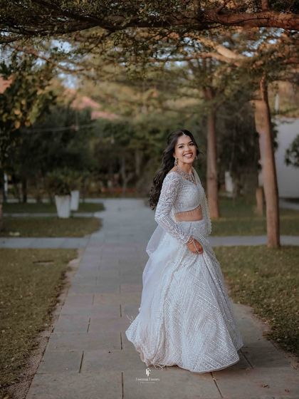 Another beautiful, smiling portrait of the bride in her white lehenga, captured mid-stride.
