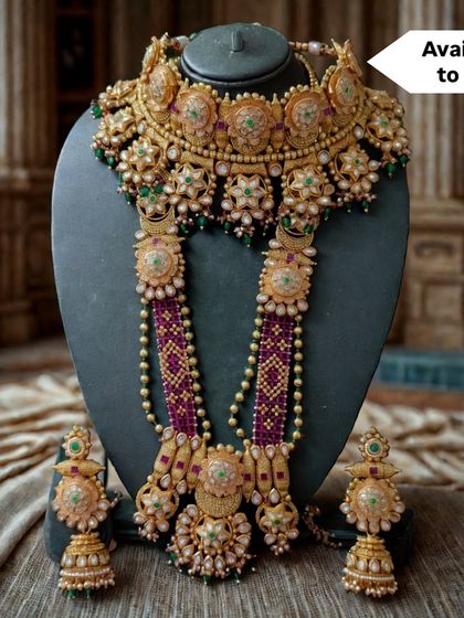 This is an exclusive for-sale bridal set featuring a floral-motif choker and a matching beaded rani haar. The combination of kundan, pearls, and colored stones makes it a timeless piece.