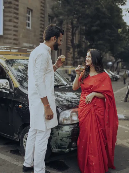 In the heart of South Bombay, we paused for a moment of quiet connection over cutting chai, with a classic kaali-peeli taxi framing this authentic, old-school romantic portrait.