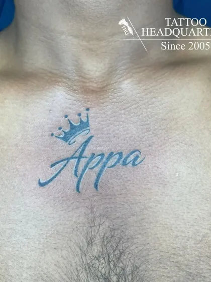 A chest tattoo of the word "Appa" (Father) with a crown on top, a sign of respect and love.