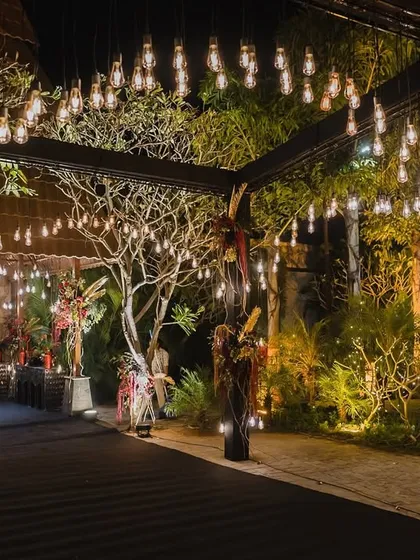 The entrance to an enchanted forest. We lined the walkway with bare branches wrapped in fairy lights and hanging bulbs, creating a magical and dramatic entrance for the evening's celebration.
