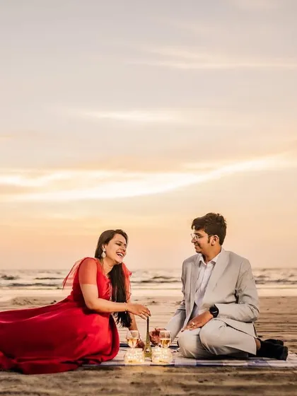Another shot from the sunset picnic series, showing the couple engaged in conversation against the beautiful evening sky.