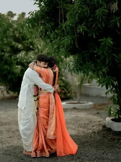 A quiet, heartfelt embrace between the couple in their wedding attire, a simple yet powerful depiction of their bond.