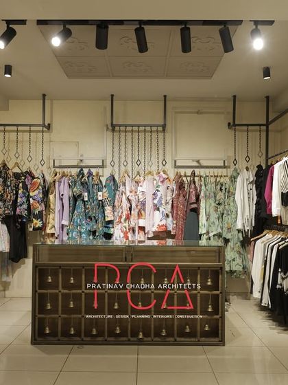 A view of the clothing display area, featuring a rustic, multi-drawer counter and industrial-style hanging racks. The design is both aesthetically pleasing and highly practical for showcasing a variety of garments.