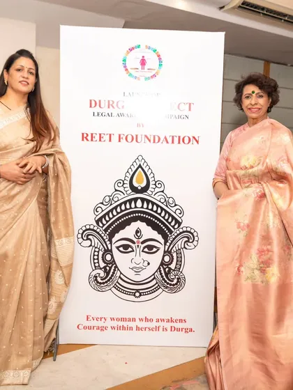 Standing beside a banner for my Reet Foundation's Project Durga with Ms. Renu Bhatia. The tagline says it all: "Every woman who awakens courage within herself is Durga."
