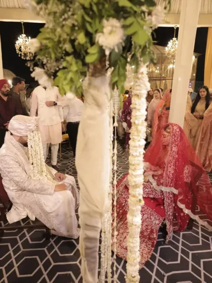 A wide view of a Muslim wedding ceremony, or Nikah. This shot captures the couple, the officiant, and the guests, showing the community aspect of the celebration.