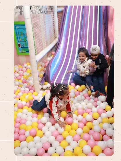 A candid moment of fun in the ball pit. Kids love diving, hiding, and playing among the thousands of soft, colorful balls.