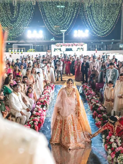 The bride's entrance is one of the most awaited moments. I designed this aisle with a reflective surface and lined it with a garden of flowers, making her walk towards the groom feel truly magical.