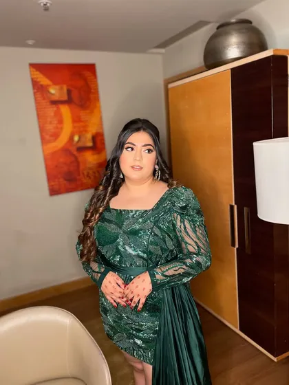 A glam goddess in this green sequin ensemble. This look is all about confidence, with a bold eye, glowing skin, and voluminous curls. Perfect for a night of celebration.